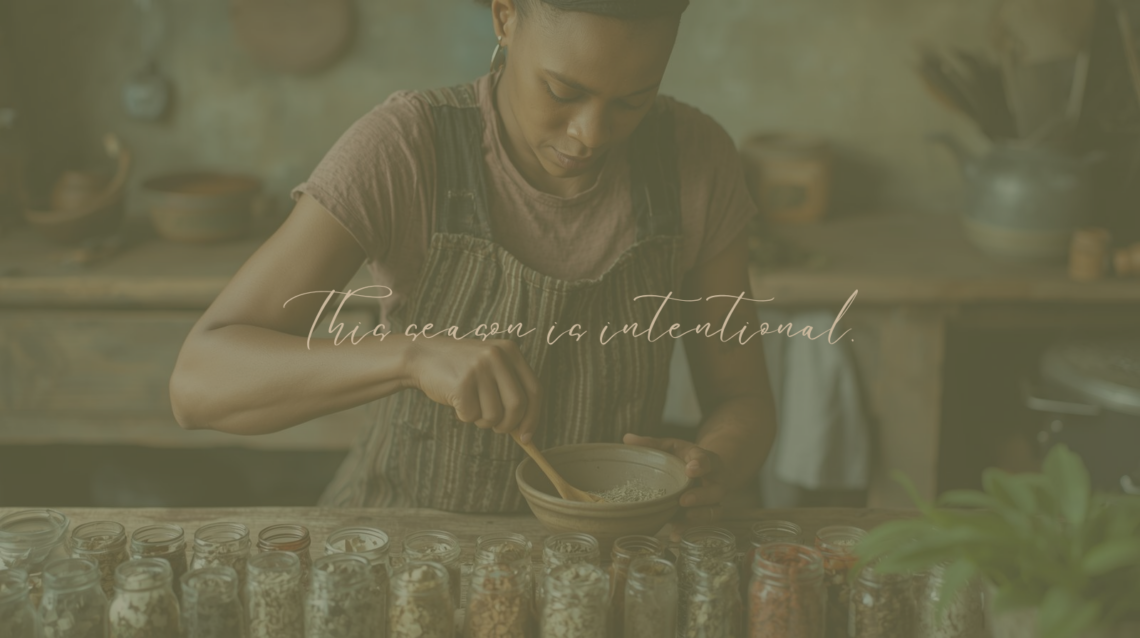 African American woman mixing dried herbs in a bowl at a kitchen table.